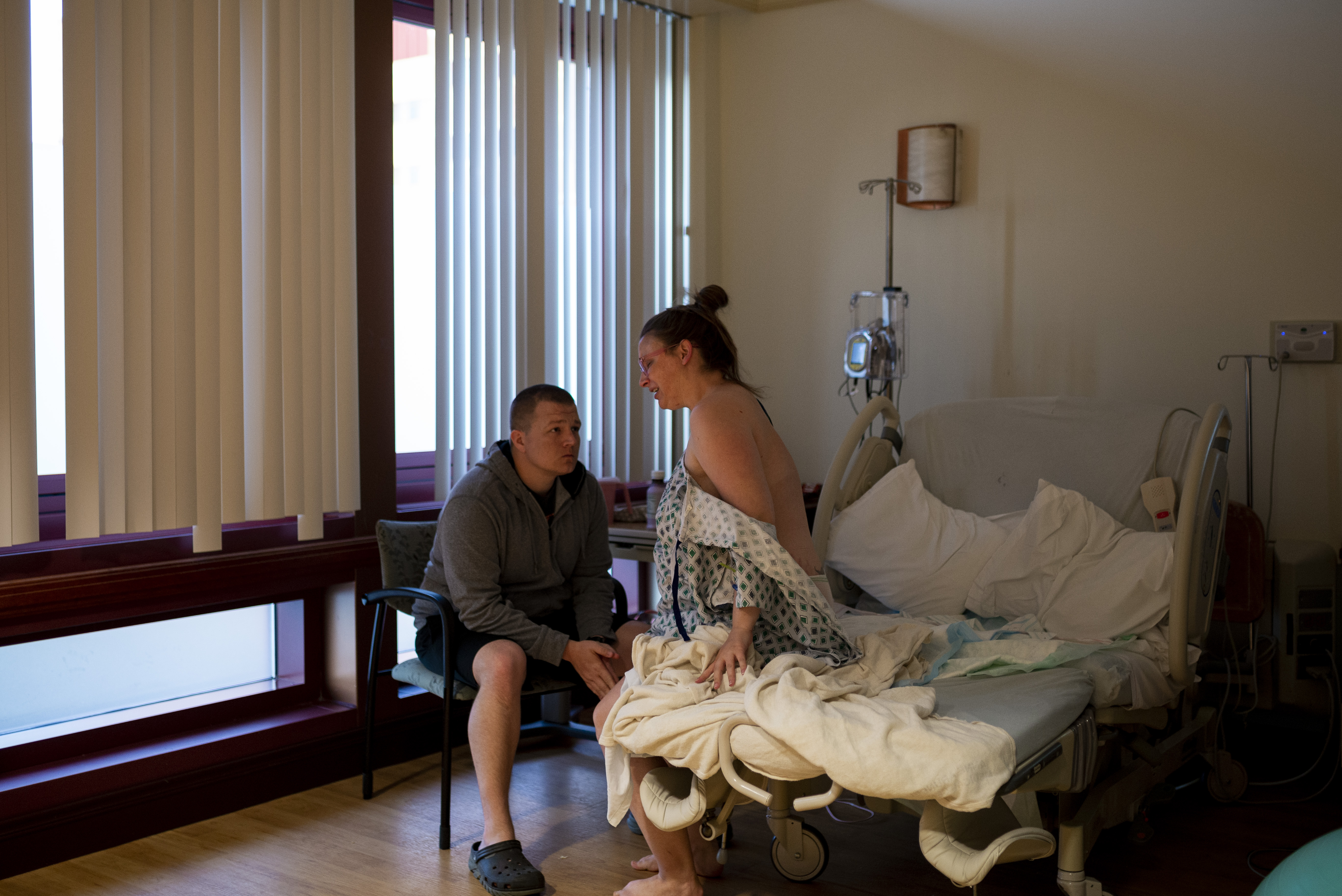 Mother sits on side of bed during active birth at hospital in Annapolis, MD