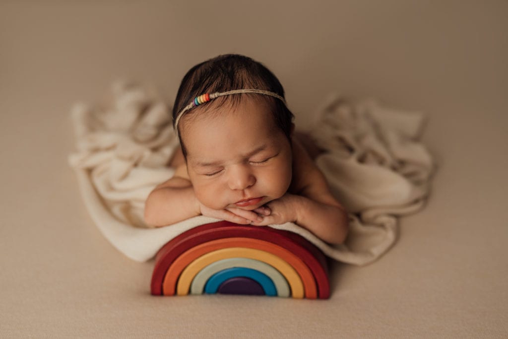 newborn baby posed on rainbown during studio newborn session in Tampa studio