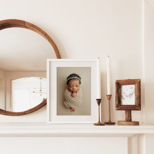 tampa newborn photographer displays framed matted portrait on a mantle in home