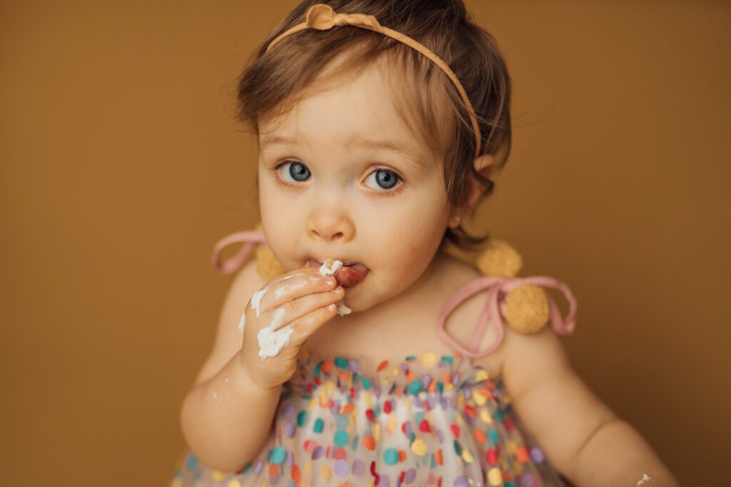 baby girl eats vegan cake during cake smash session in tampa